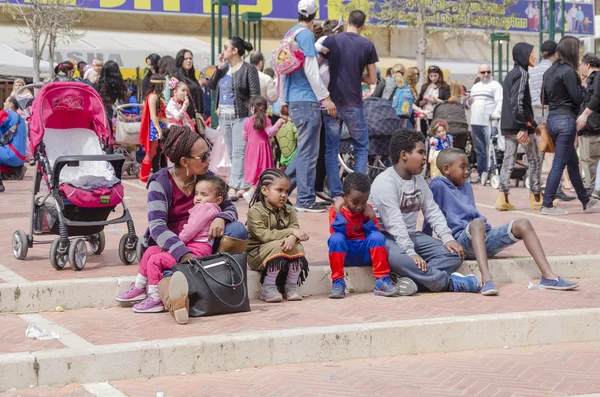 Beer-Sheva, ISRAEL - March 5, 2015:  Children in carnival costumes with their parents on the street in celebration of Purim