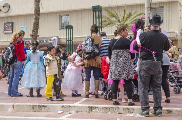 Beer-Sheva, ISRAEL - March 5, 2015:  Children in carnival costumesare back with their parents on the street in celebration of Purim
