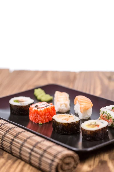 Fresh Japanese tasty sushi roll set with chopsticks on wooden ta