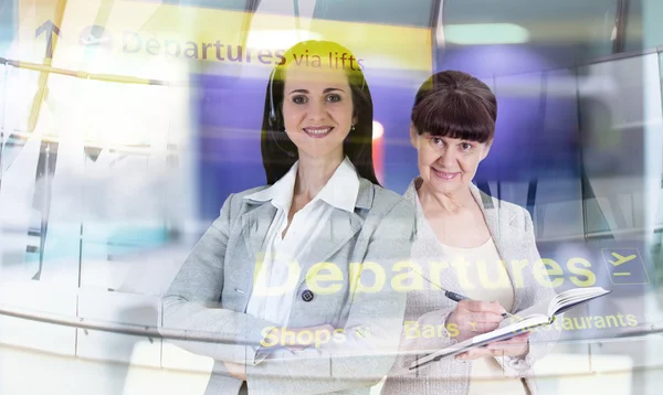 Two attractive woman portrait in office against of glass reflection, business background