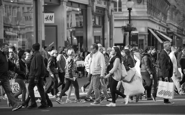 Regent street with lots of walking people crossing the road. London