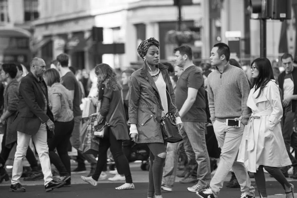 Regent street with lots of walking people crossing the road. London