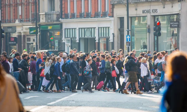 Regent street with lots of walking people crossing the road. London