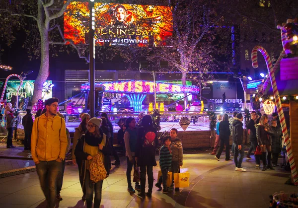 London, Leicester square traditional fun fair with stools, carrousel, prises to win and Christmas activity. People and families enjoying Christmas mood night out