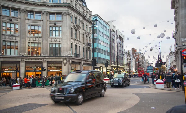 LONDON, UK - NOVEMBER 30, 2014: Regent street, Oxford circus with lots of pedestrians and cars, taxis on the road.