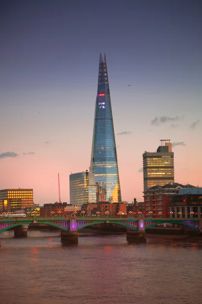LONDON, UK - DECEMBER 19, 2014: Shard of glass in the dusk. City of London business aria. Thames view from the bridge