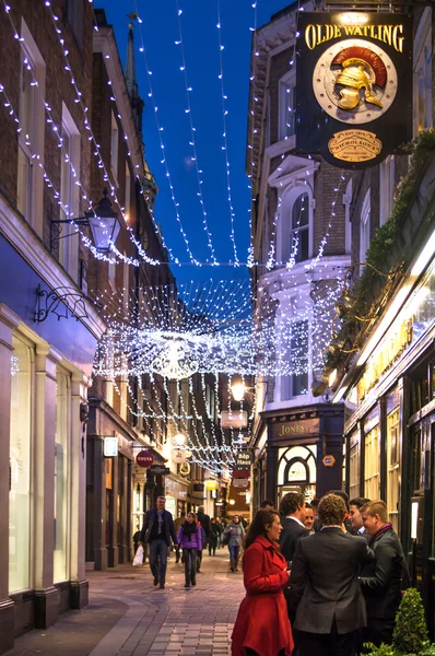 LONDON, UK - DECEMBER 19, 2014: Old City street leading to st. Paul cathedral. Street view with evening lights and public house