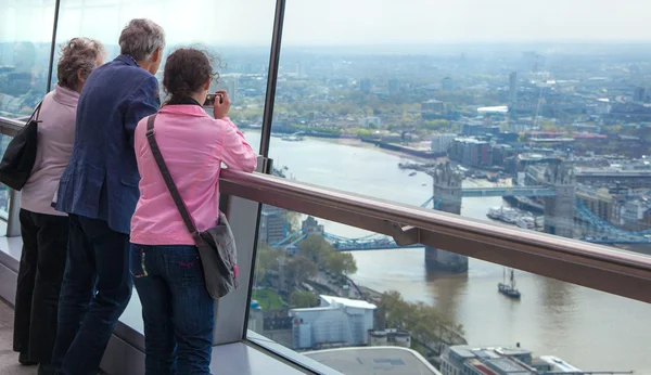 LONDON, UK - APRIL 22, 2015: People looking at the London\'s skyline. Viewing platform of Walkie-Talkie building. Locates on 32 floor and offering amazing view of the city.