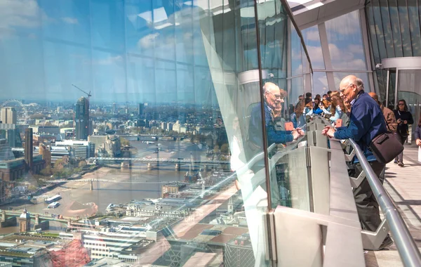 LONDON, UK - APRIL 22, 2015: People looking at the London's skyline. Viewing platform of Walkie-Talkie building. Locates on 32 floor and offering amazing view of the city.