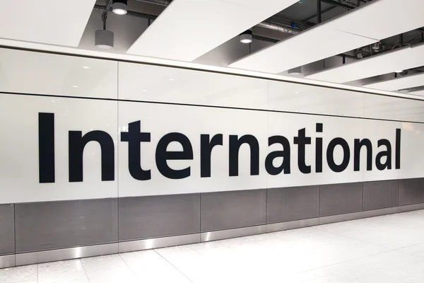 LONDON, UK - MARCH 28, 2015: International arrivals sign. Interior of  Heathrow airport Terminal 5. New building