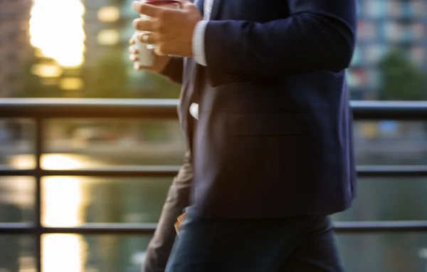 Business man in suit walking against of sunset light, London