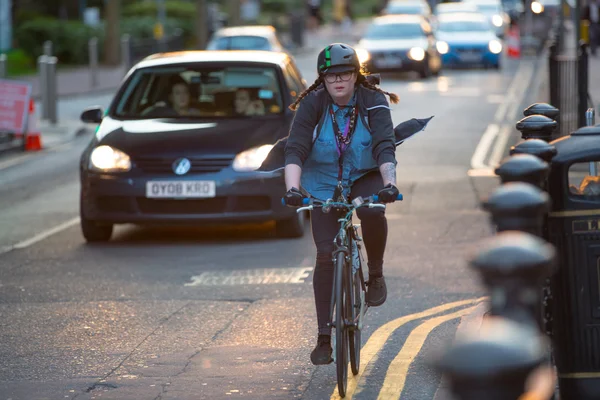 LONDON, UK - 7 SEPTEMBER, 2015: Londoners commuting from work by bike. Road view with cars and cyclers