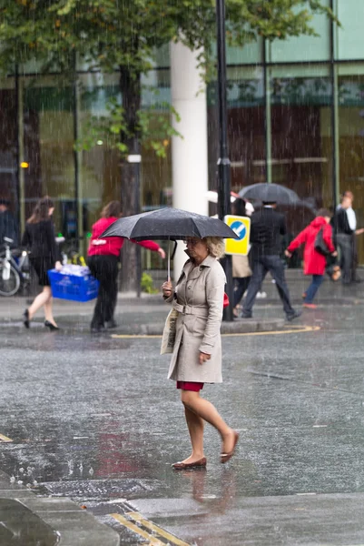 LONDON, UK - SEPTEMBER 17, 2015: Woman with umbrella  walking in rain. City of London