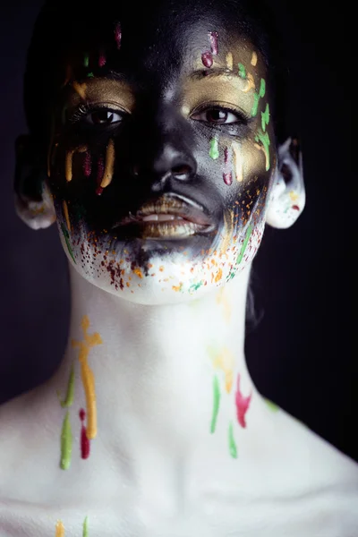 Woman with creative makeup closeup like drops of colors, facepaint close up halloween