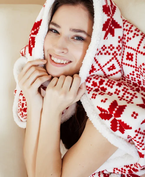 Young pretty brunette girl in Christmas ornament blanket getting warm on cold winter, freshness beauty concept