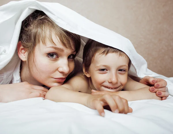 Young blond woman with little boy in bed, mother and son, happy familyyoung blond woman with little boy in bed, mother and son, happy family