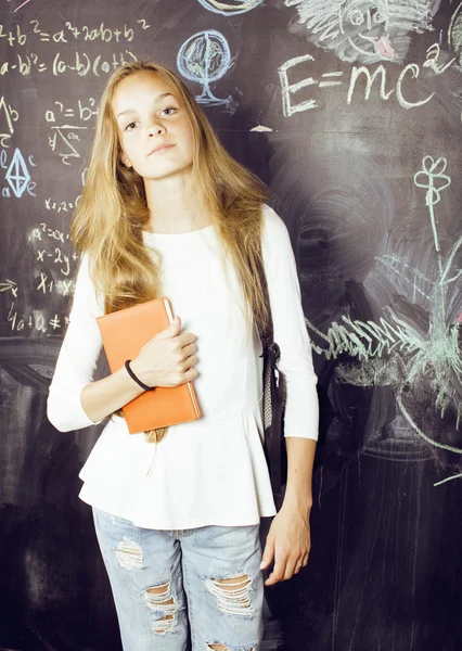 Back to school after summer vacations, teen real girl in classroom with blackboard painted together