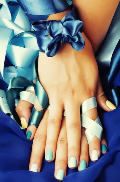 Blue manicure with ribbon close up