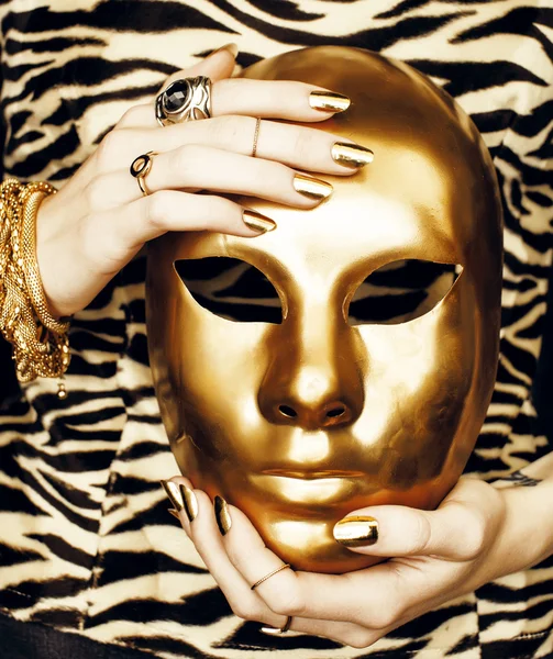 Woman hands holding golden carnival mask