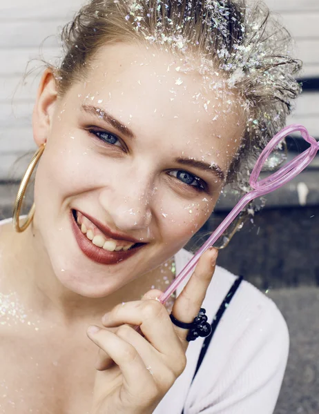 Young pretty party girl smiling covered with glitter tinsel, fashion dress, stylish make up, lifestyle people concept close up