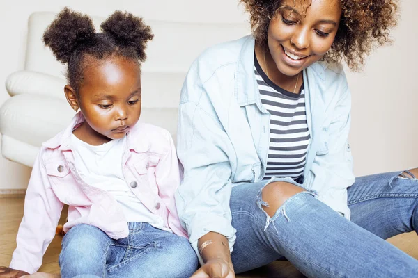Adorable sweet young afro-american mother with cute little daughter, hanging at home, having fun playing smiling, lifestyle people concept