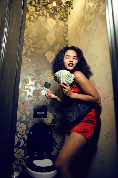 Pretty young african american woman in luxury restroom with money, like prostitute