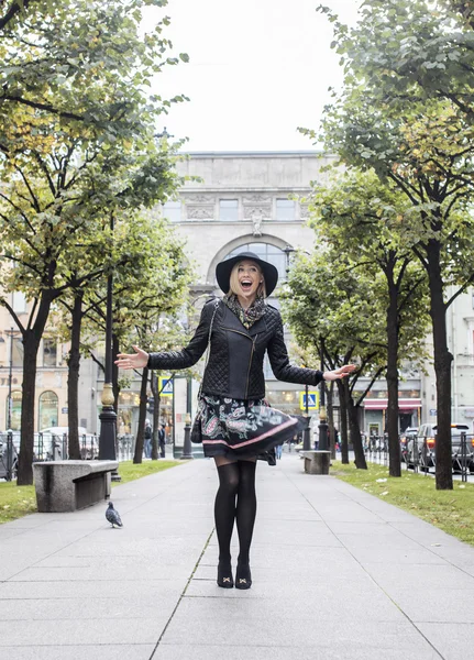 Young pretty blond woman in stylish hat, street fashion european cold weather, city life