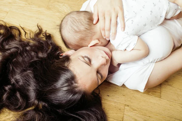 Young brunette happy mother holding toddler baby son, breast-feeding concept, lifestyle modern people