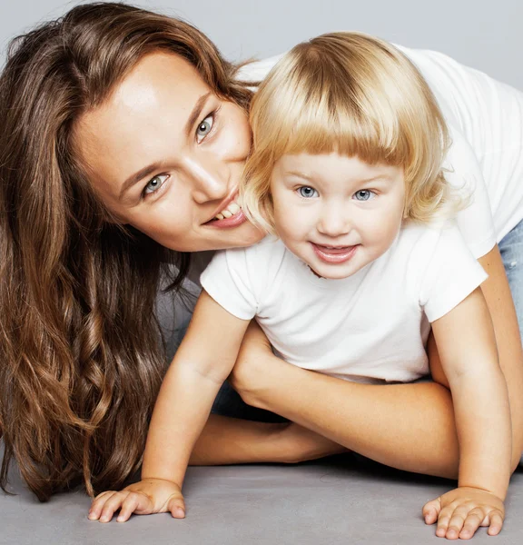 Young pretty stylish mother with little cute blond daughter hugging, happy smiling family, lifestyle people concept