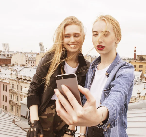 Two cool blond real girls friends making selfie on roof top, lifestyle people concept