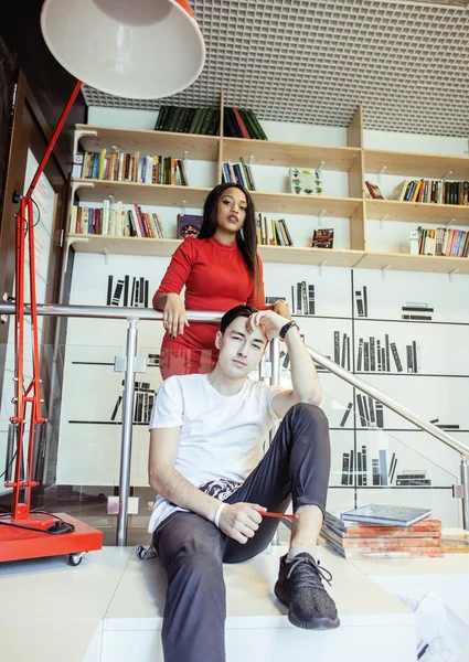 Couple students in univercity library, looking book, preparing to exam, having fun, making selfie