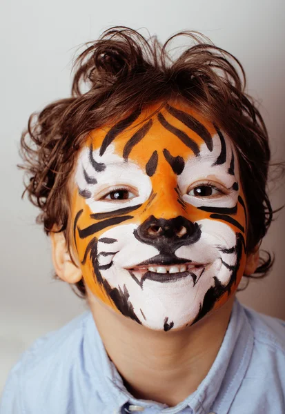 Little cute boy with faceart on birthday party close up, little cute tiger