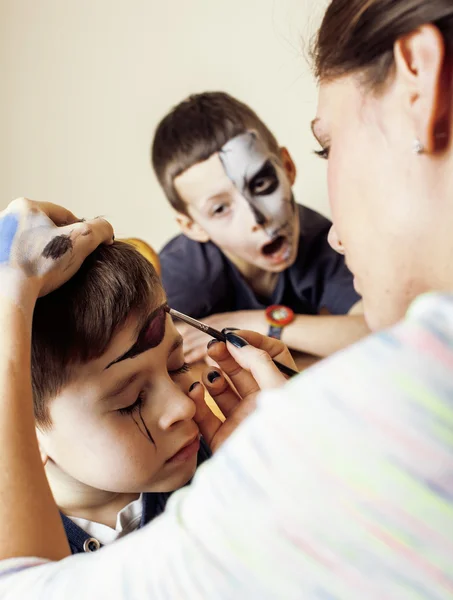 Little cute child making facepaint on birthday party, zombie Apocalypse facepainting, halloween preparing concept