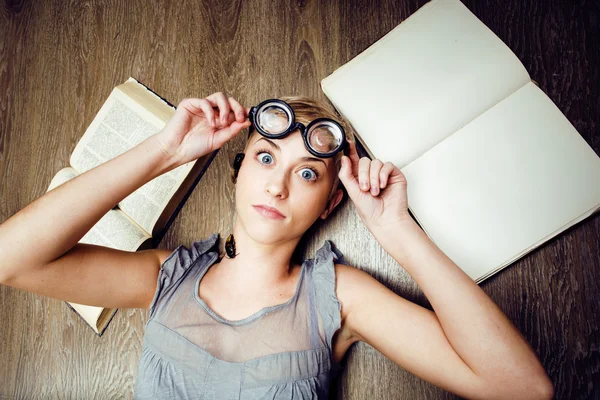 Portrait of crazy student girl in glasses with books and cockroaches, concept of modern education people, lifestyle portrait in interior