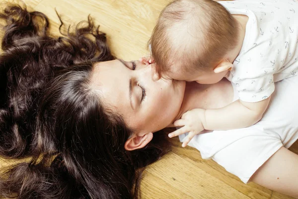 Young brunette happy mother holding toddler baby son, breast-feeding concept, lifestyle happy modern people smiling