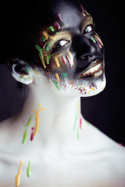 Woman with creative makeup closeup like drops of colors, facepaint close up halloween