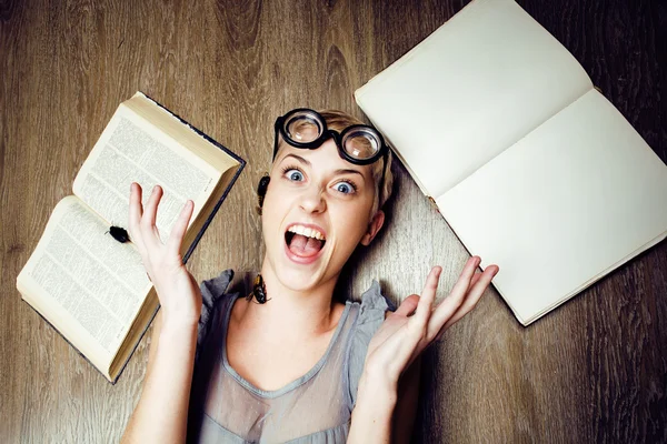 Portrait of crazy student girl in glasses with books and cockroaches, concept of modern education people, lifestyle portrait in interior