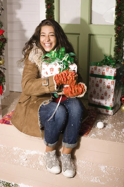Happy young girl at home decorated on Christmas, bringing gifts to friends