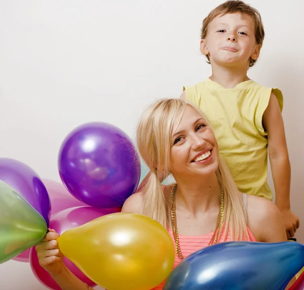 Pretty family with color balloons on white background, blond woman with little boy at birthday