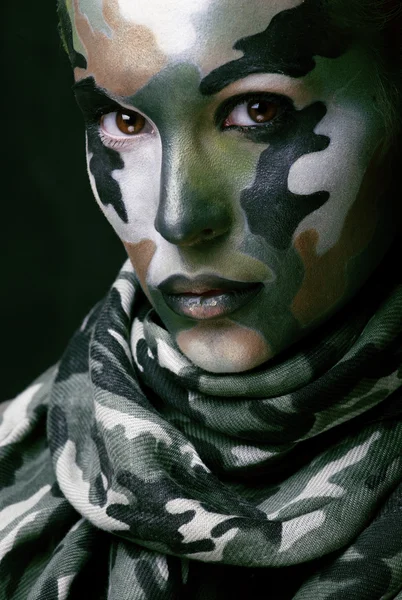 Beautiful young fashion woman with military style clothing and face paint make-up, khaki colored