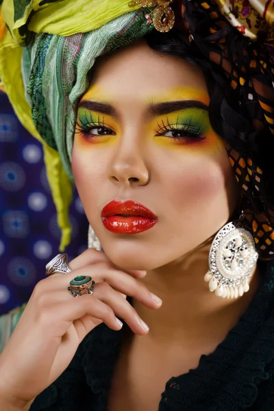 Beauty bright woman with creative make up, many shawls on head like cubian woman