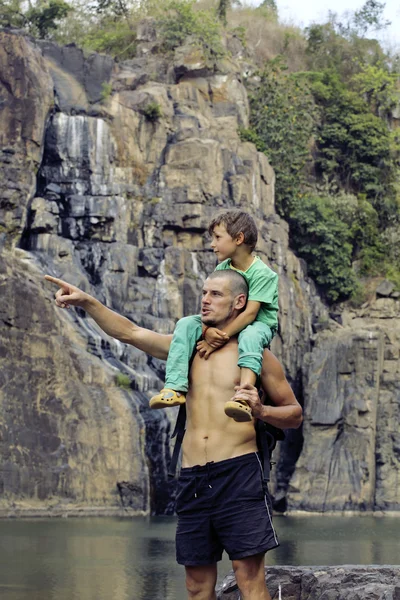 Father and son making a trip to waterfall together, happy family on vacations, nature place pongour