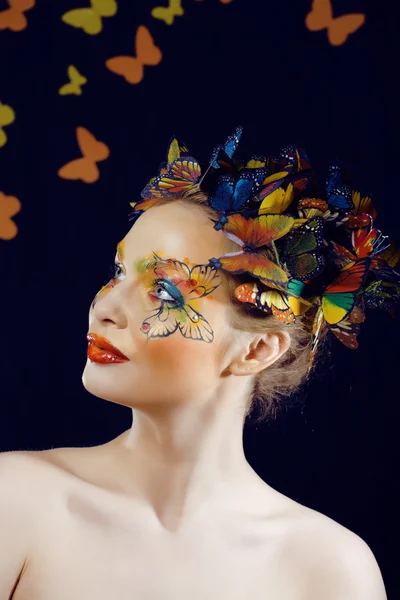 Woman with summer creative make up like fairy butterfly closeup bright colored background