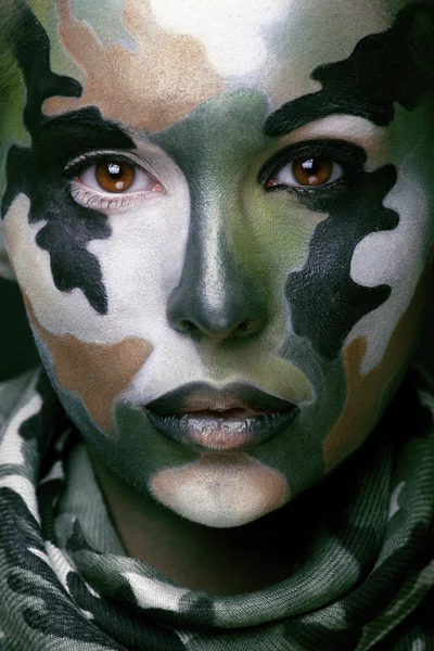 Beautiful young fashion woman with military style clothing and face paint make-up, khaki colors, halloween celebration swag