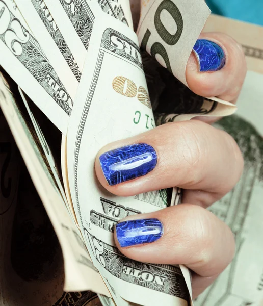 Hands of young caucasian woman with blue manicure at casino table close up, deep indigo design on nails