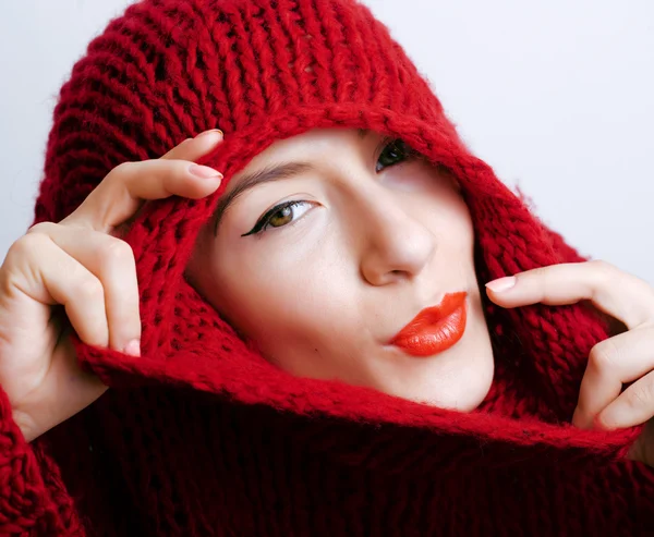 Young pretty woman in sweater and scarf all over her face, winter cold close up