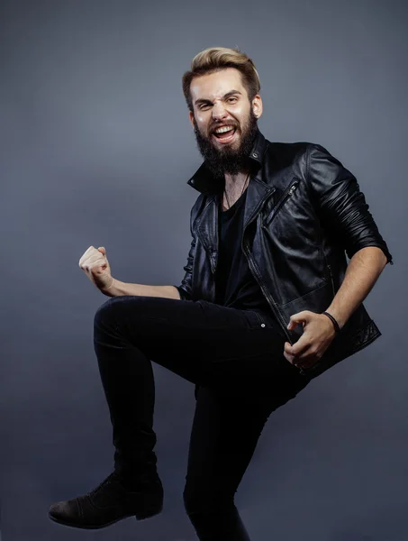 Young attractive bearded hipster man gesturing emotional screaming in studio sucsess