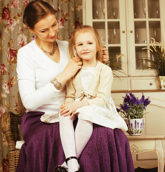 Young mother with daughter at luxury home interior vintage
