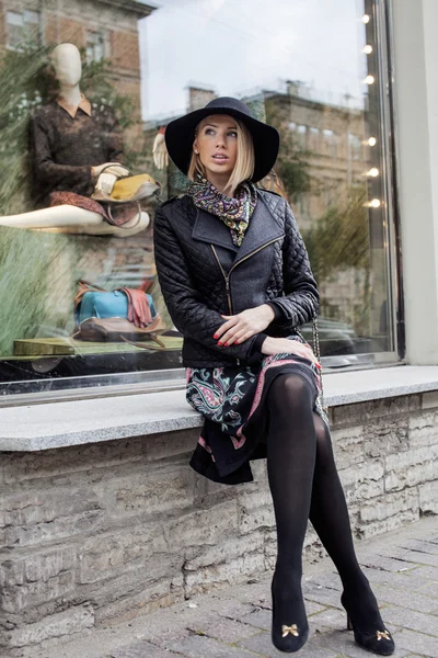 Young pretty blond woman in stylish hat, street fashion european cold weather, city life