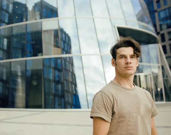 Young man stand in front of modern business building, dreams come true hands up enjoying gesturing